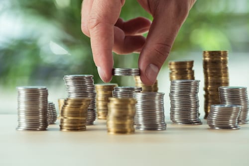 Person stacking coins, symbolizing only paying for what you need with Microsoft Azure.