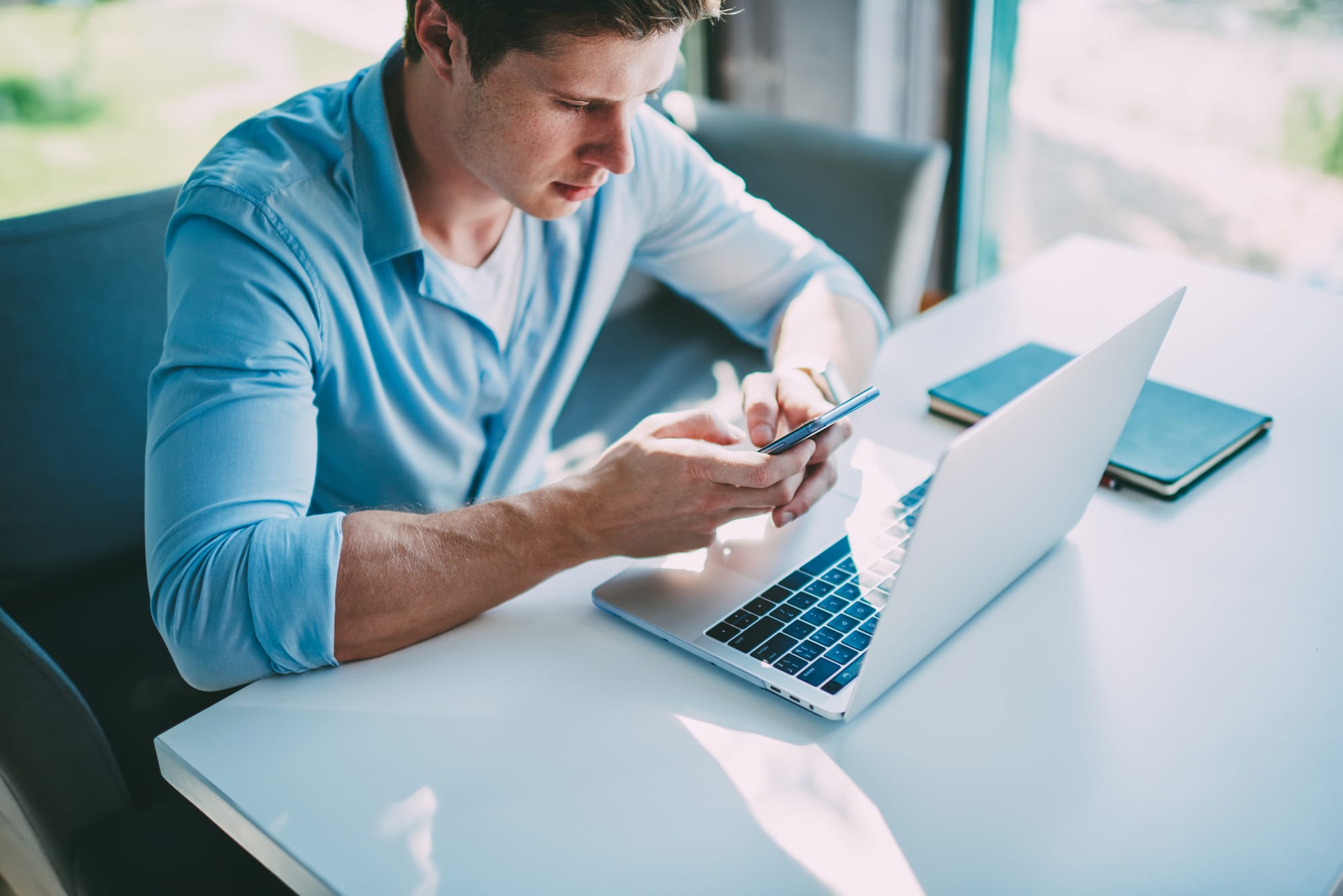 Manager using laptop and phone to implement website security.